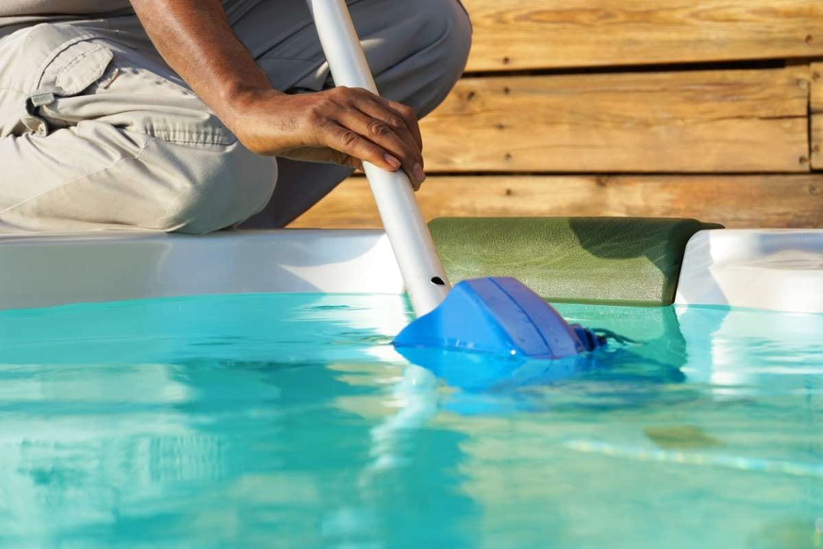 African hotel staff worker cleaning a pool