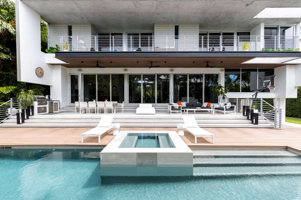 Modern backyard with a swimming pool, stone path, and outdoor seating