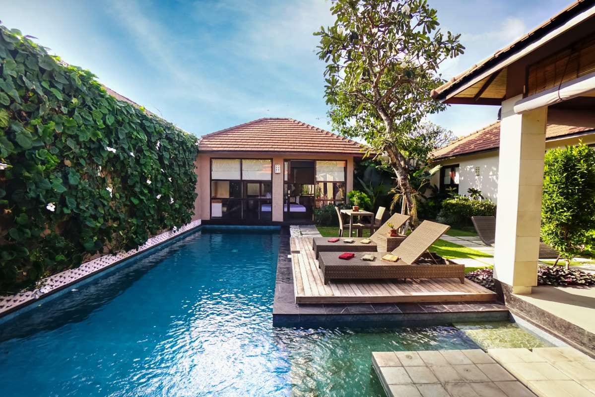 Contemporary home with tropical landscaping and a blue backyard pool