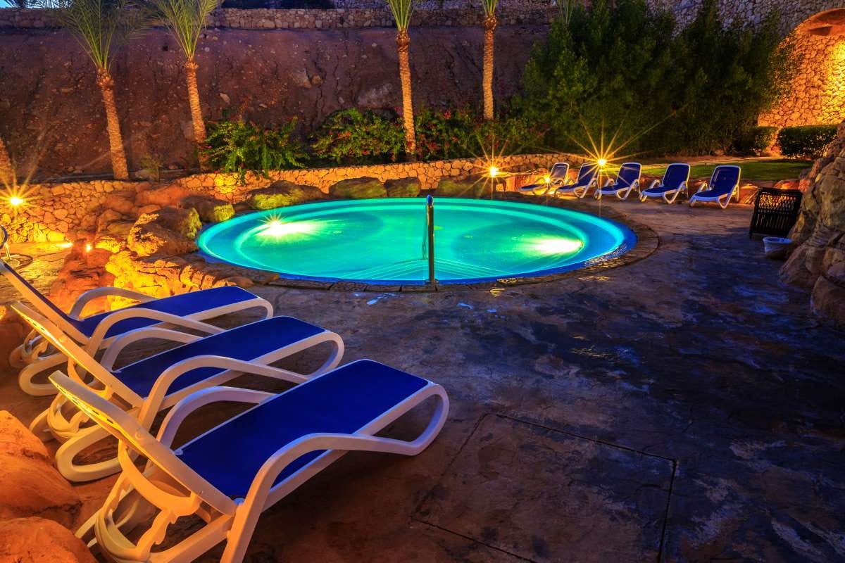 Luxury swimming pool lit up at night in the evening view