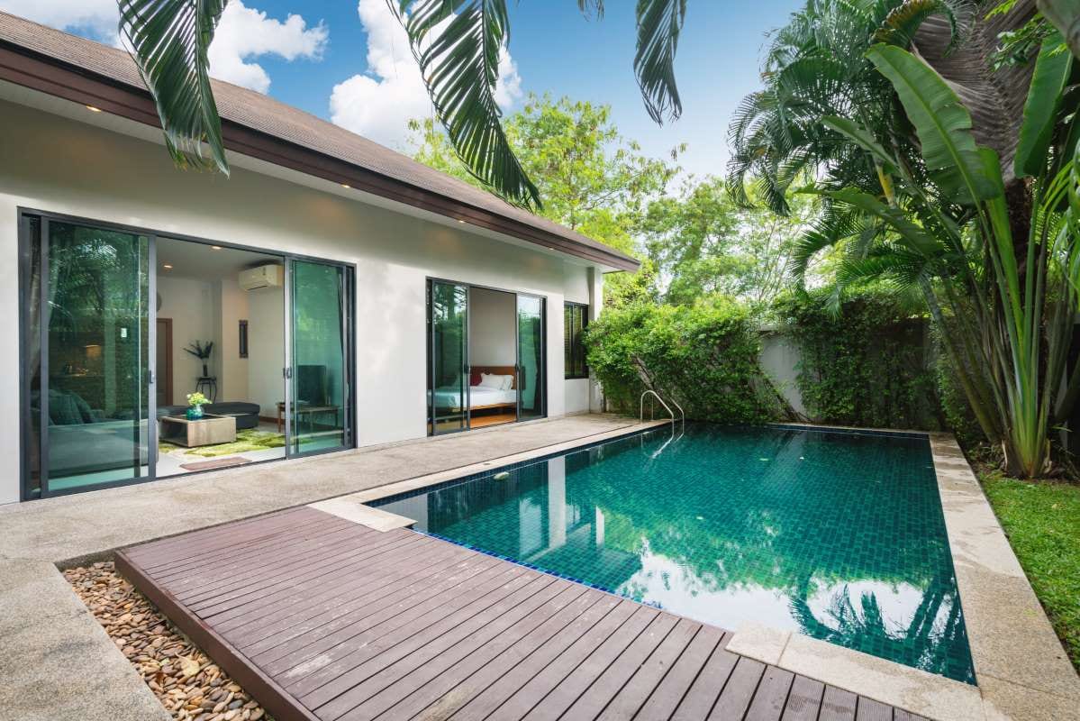 Modern villa exterior with swimming pool, garden terrace, and decking
