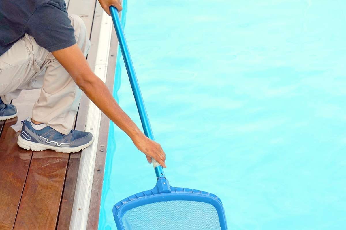 Hotel staff member cleaning a pool at a hotel
