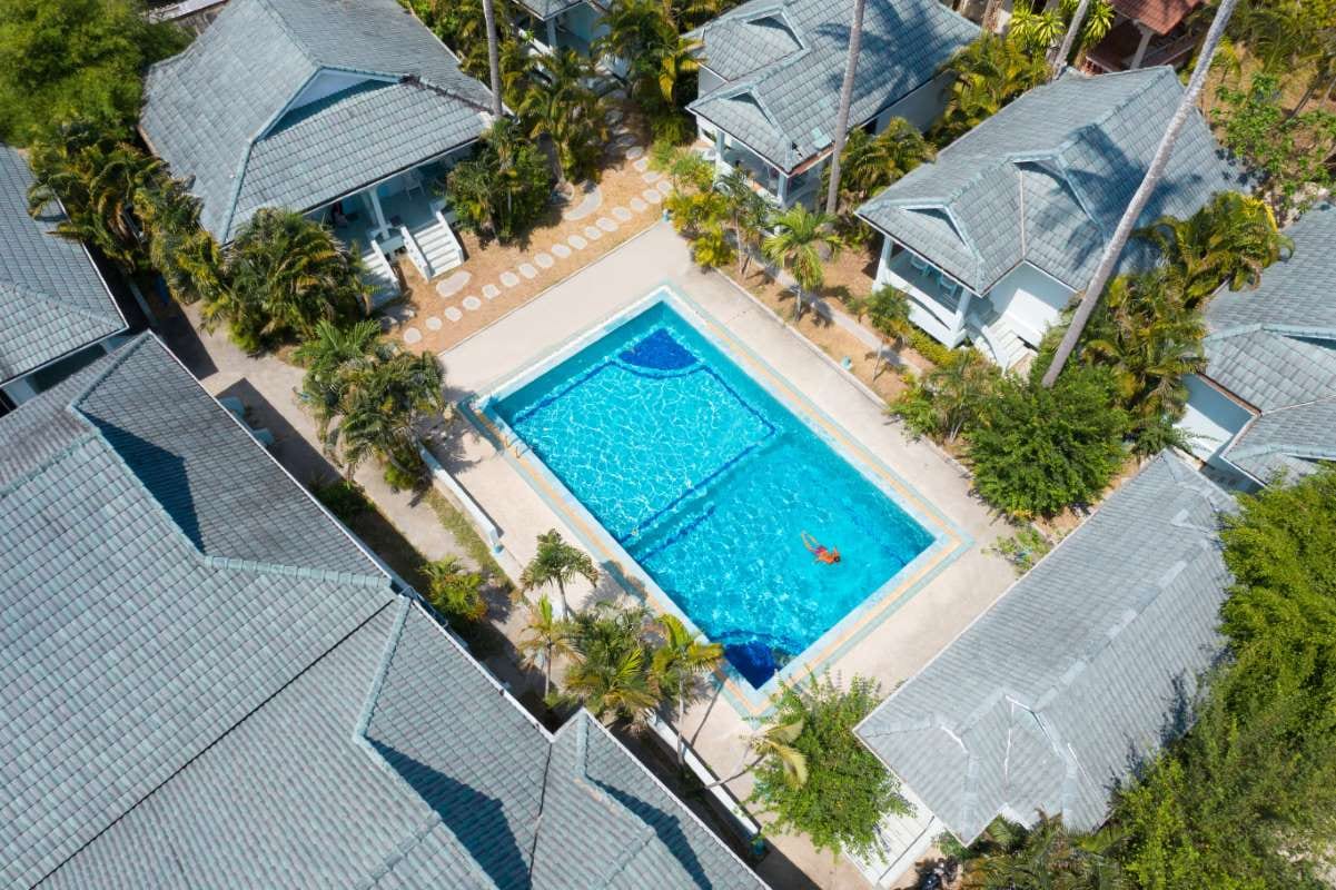 Large apartment complex with a swimming pool and landscaped grounds