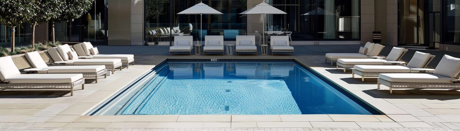 Modern minimalist poolside lounge area beside a swimming pool