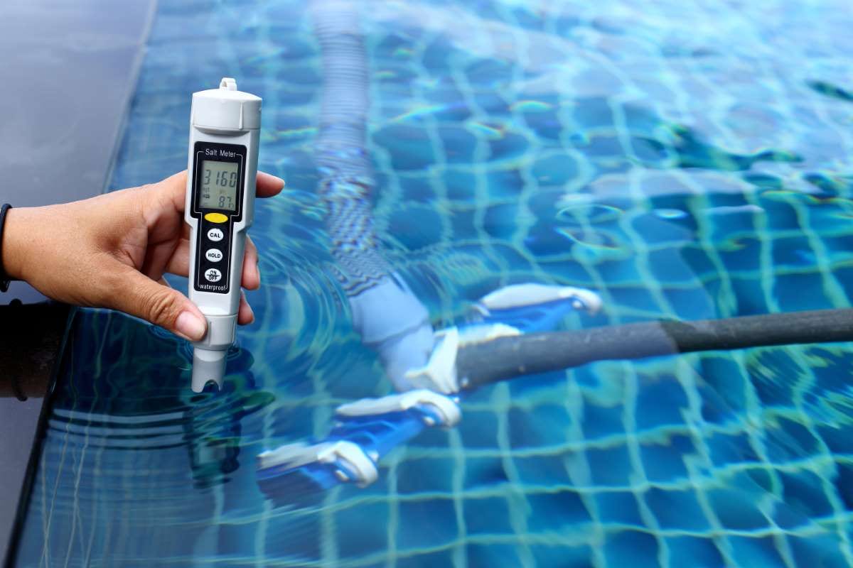 Technician checking salt meter levels at a resort private pool during weekly maintenance