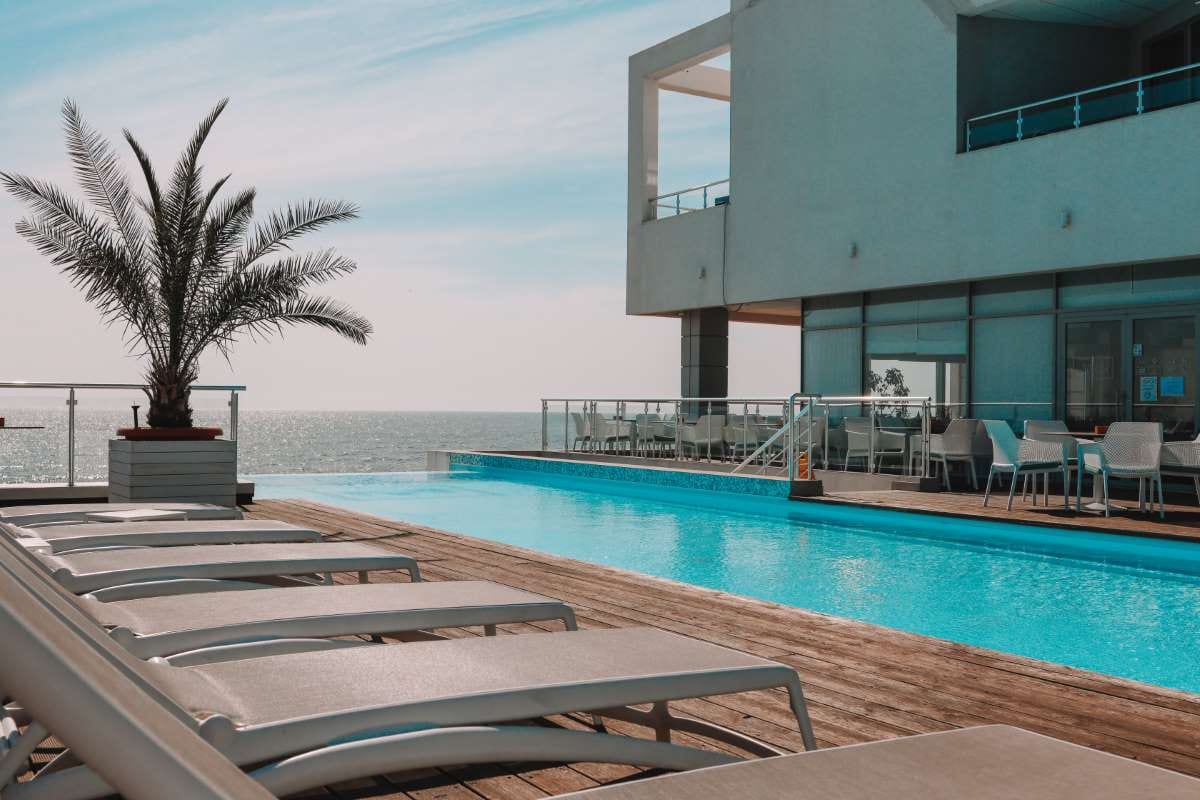 Sunny hotel pool with loungers, suggesting relaxation and summer leisure
